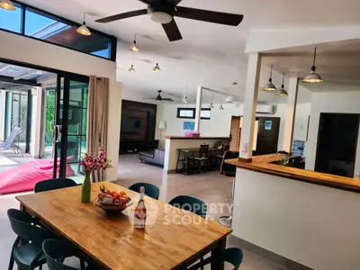Spacious open-plan living area with modern kitchen and dining, featuring large windows and stylish decor.