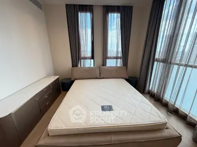 Spacious bedroom with large windows and modern furniture, offering a serene ambiance.