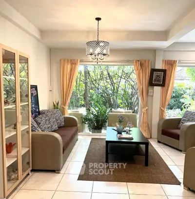 Charming living room with cozy seating and lush garden view, perfect for relaxation.