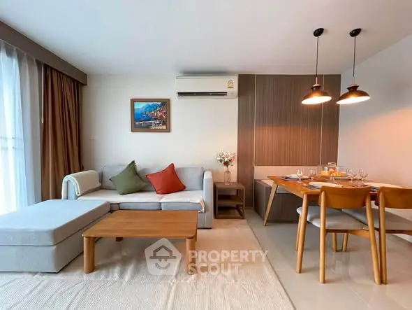 Modern living room with cozy sofa, dining area, and stylish decor in a bright apartment.