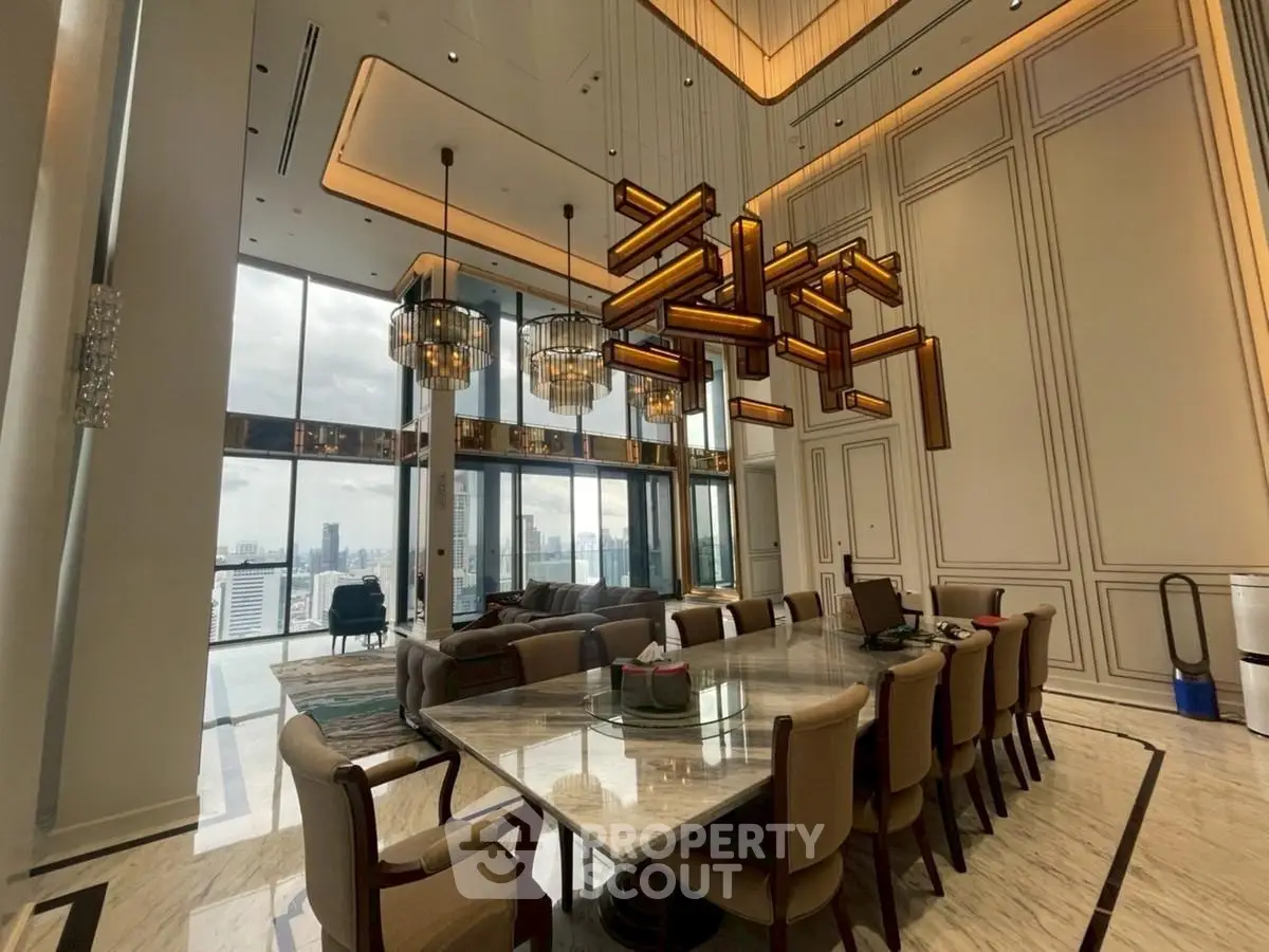 Luxurious high-ceiling living room with modern chandelier and panoramic city views.