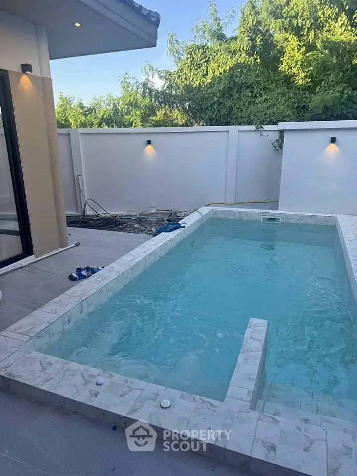 Luxurious private pool with elegant stone tiling and modern lighting, perfect for relaxation and entertainment.