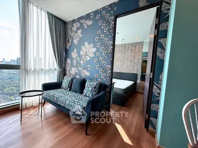 Stylish living room with modern decor and city view, adjacent to a cozy bedroom.