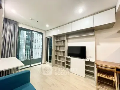 Modern living room with built-in shelves and balcony view in urban apartment.