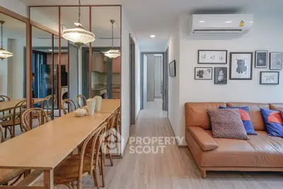 Stylish living room with modern decor, leather sofa, and elegant dining area in a contemporary apartment.