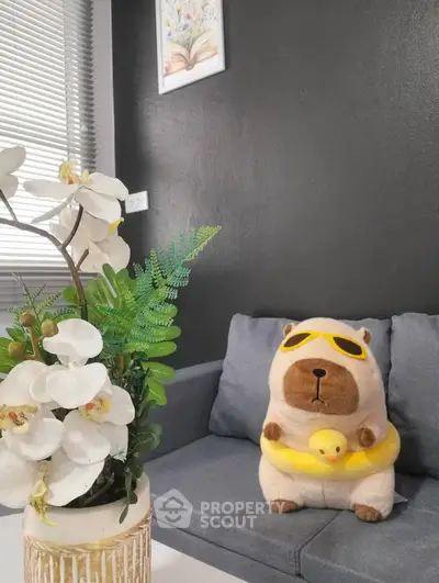Cozy living room with plush toy and decorative plant on a modern sofa.