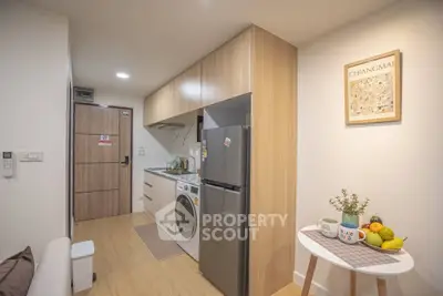Modern compact kitchen with washing machine and fridge in cozy apartment
