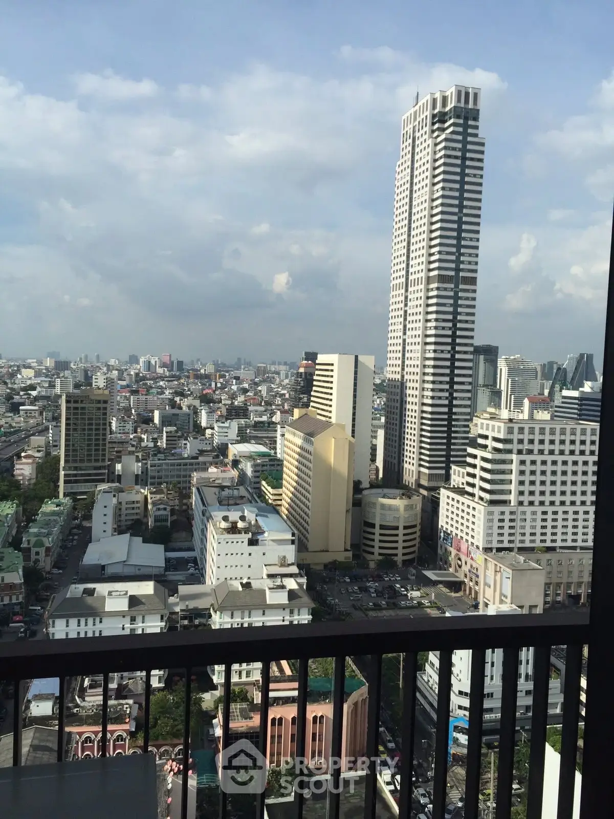 Stunning cityscape view from a high-rise balcony showcasing urban skyline and towering skyscrapers.