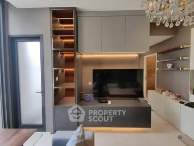 Modern living room with sleek cabinetry and elegant chandelier