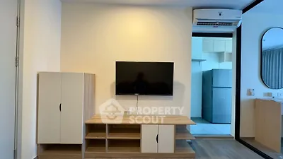 Modern living room with wall-mounted TV and sleek furniture design.