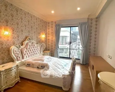 Luxurious bedroom with elegant decor and large window offering city view