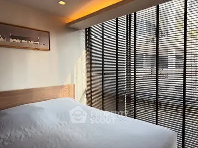 Modern bedroom with large windows and stylish blinds, offering a serene and cozy atmosphere.
