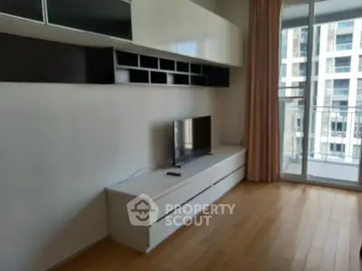 Modern living room with sleek TV unit and balcony view in urban apartment