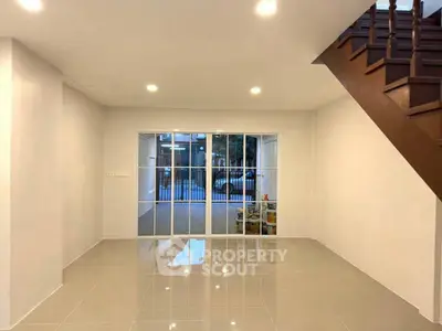 Spacious modern living room with sleek tile flooring and staircase