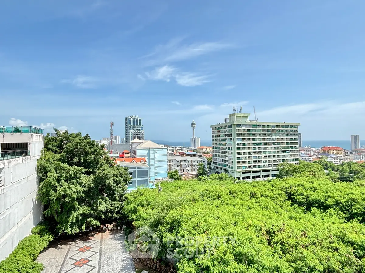 Stunning cityscape view with lush greenery and modern buildings under a clear blue sky.
