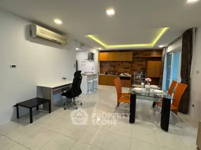 Spacious modern living room with open kitchen and dining area, featuring sleek furniture and ambient lighting.