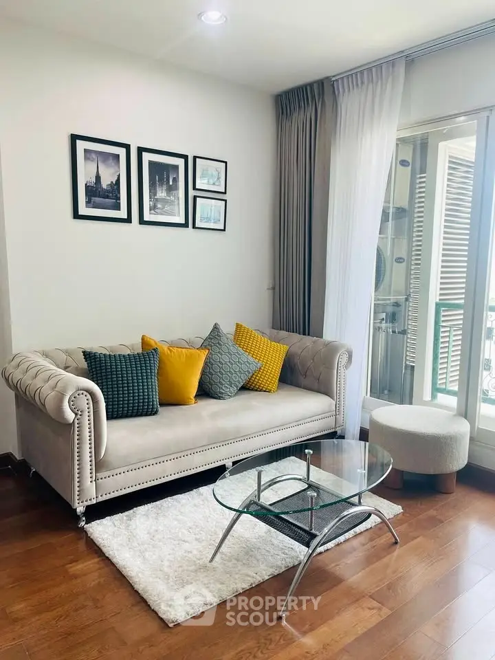 Stylish living room with elegant sofa, glass coffee table, and balcony view in modern apartment.