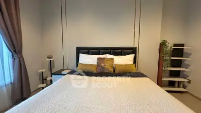 Cozy bedroom with stylish decor and ample natural light, perfect for relaxation and comfort.
