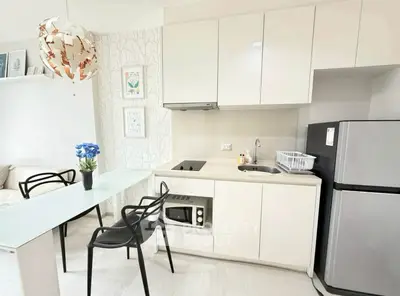 Modern kitchen with sleek cabinets, dining area, and stylish decor