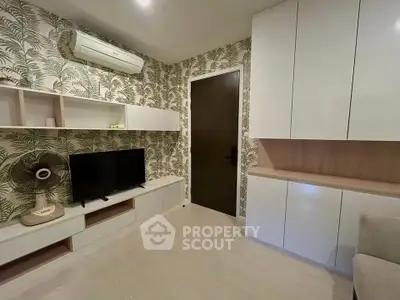 Stylish living room with modern decor and built-in storage, featuring tropical wallpaper and sleek air conditioning.