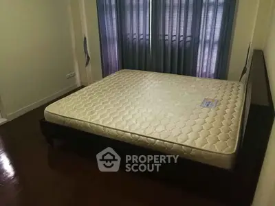 Spacious bedroom with large bed and elegant curtains, perfect for restful nights.