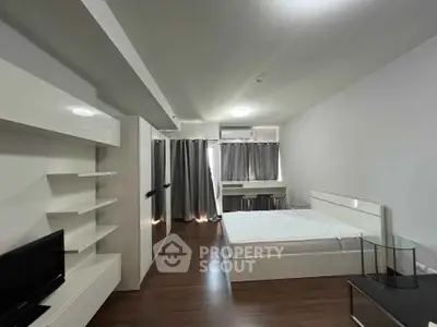 Modern bedroom with sleek white furniture and hardwood floors