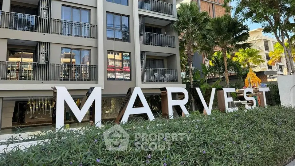 Modern condominium building with lush greenery and stylish facade in prime location.