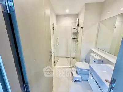 Modern bathroom with glass shower and sleek fixtures in a contemporary apartment.