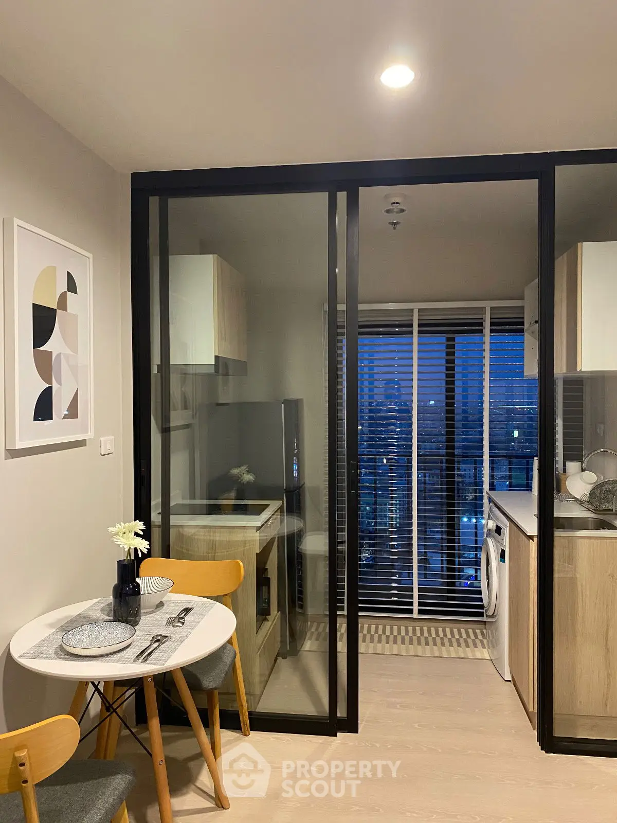 Modern kitchen with open layout and dining area, featuring sleek appliances and stylish decor.