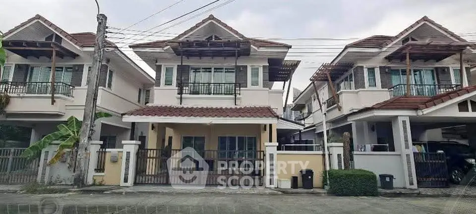 Charming suburban homes with tiled roofs and spacious driveways in a peaceful neighborhood.