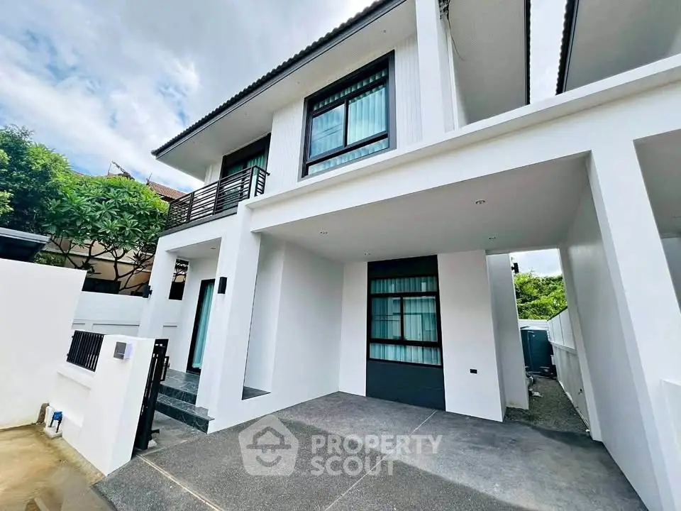 Modern two-story house with sleek design and spacious driveway, perfect for contemporary living.