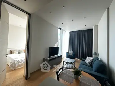 Modern living room with cozy seating and natural light, adjacent to a stylish bedroom.
