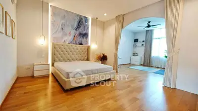 Spacious bedroom with elegant decor and wooden flooring