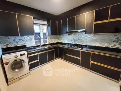 Modern kitchen with sleek black cabinetry and built-in washing machine