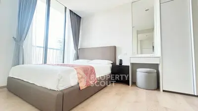Modern bedroom with large windows and stylish furniture in a high-rise apartment.