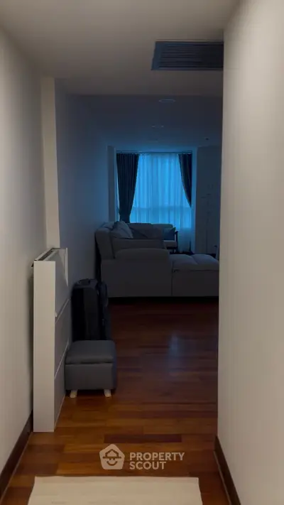 Cozy living room with modern sofa and wooden flooring, perfect for relaxation.