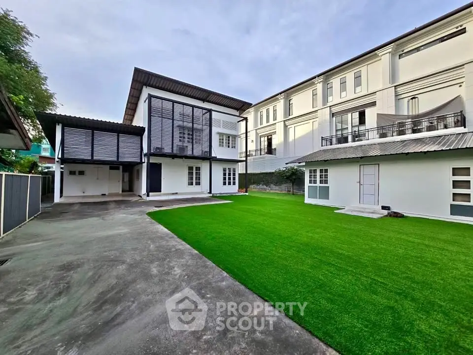 Spacious modern home with lush green lawn and sleek architectural design, perfect for family living.