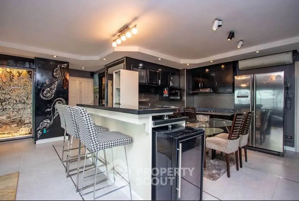 Modern kitchen with sleek black cabinetry and stylish breakfast bar seating