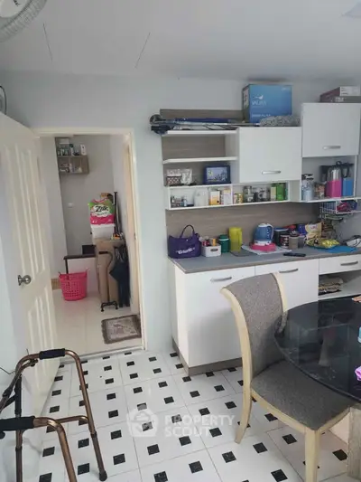 Cozy kitchen with open shelving and dining area, featuring modern appliances and stylish decor.