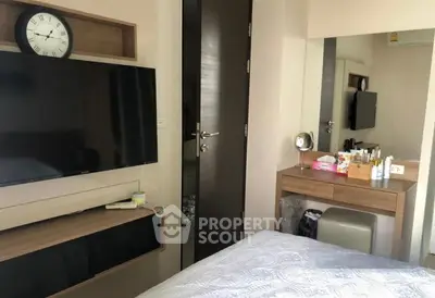 Cozy bedroom with modern TV setup and stylish vanity area