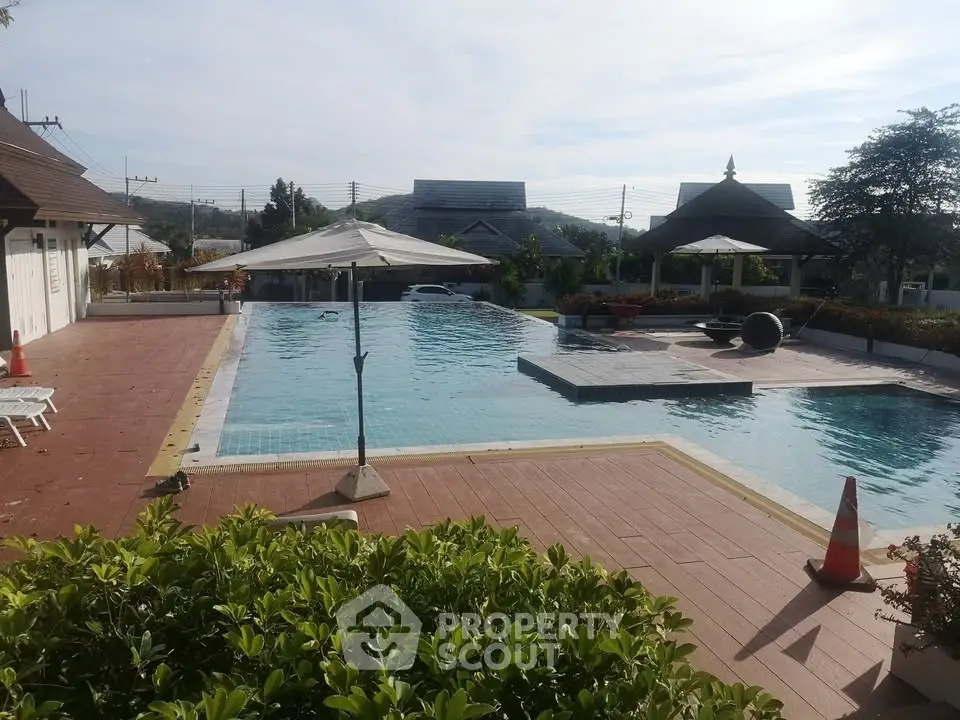 Luxurious outdoor pool area with scenic views and relaxing amenities in a serene real estate setting.