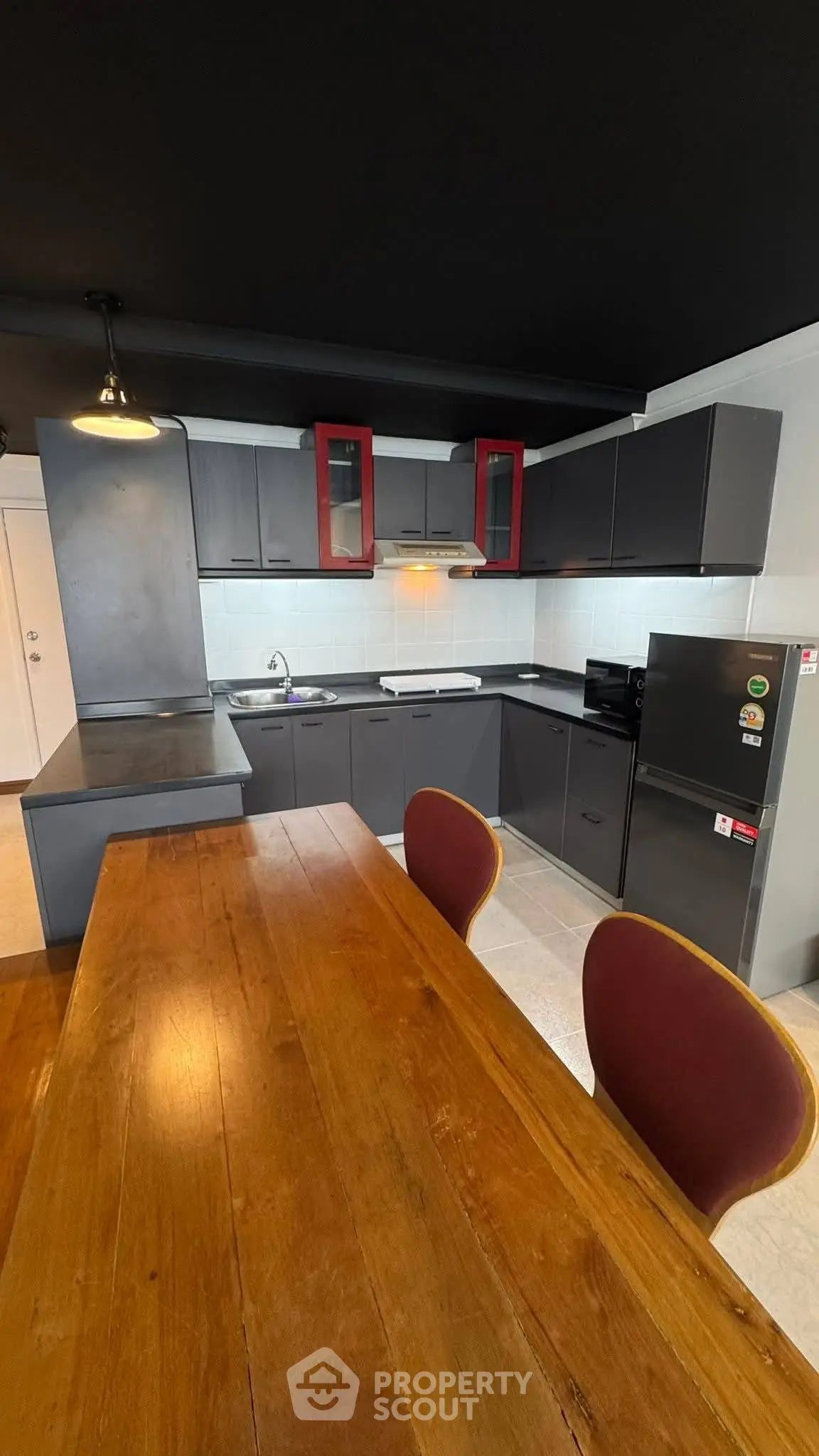 Modern kitchen with sleek black cabinets and wooden dining table