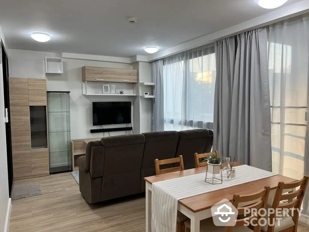 Spacious and modern living room with elegant furniture, a large comfortable sofa, and a flat-screen TV, perfect for family gatherings and entertainment.