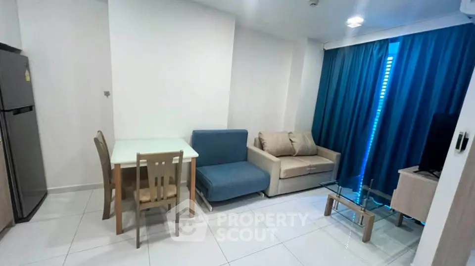 Modern living room with cozy seating and dining area, featuring sleek furniture and bright natural light.