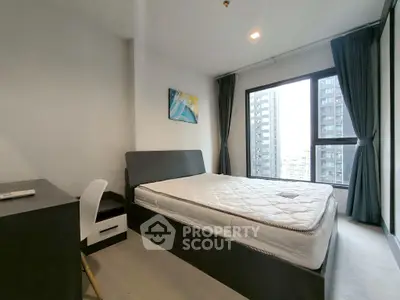 Modern bedroom with large window and city view in high-rise apartment