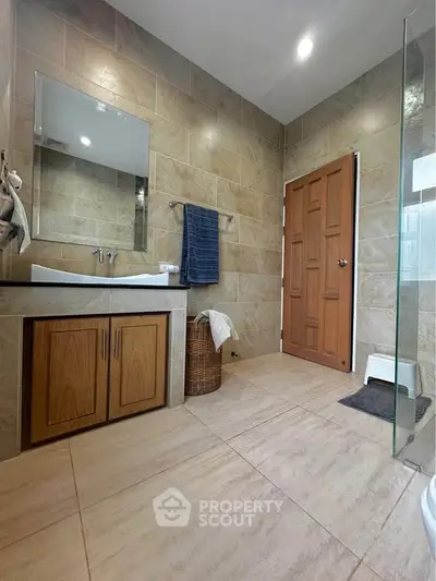 Modern bathroom with elegant tile design and wooden cabinetry