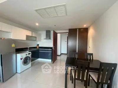 Modern kitchen with dining area, featuring sleek appliances and contemporary design.