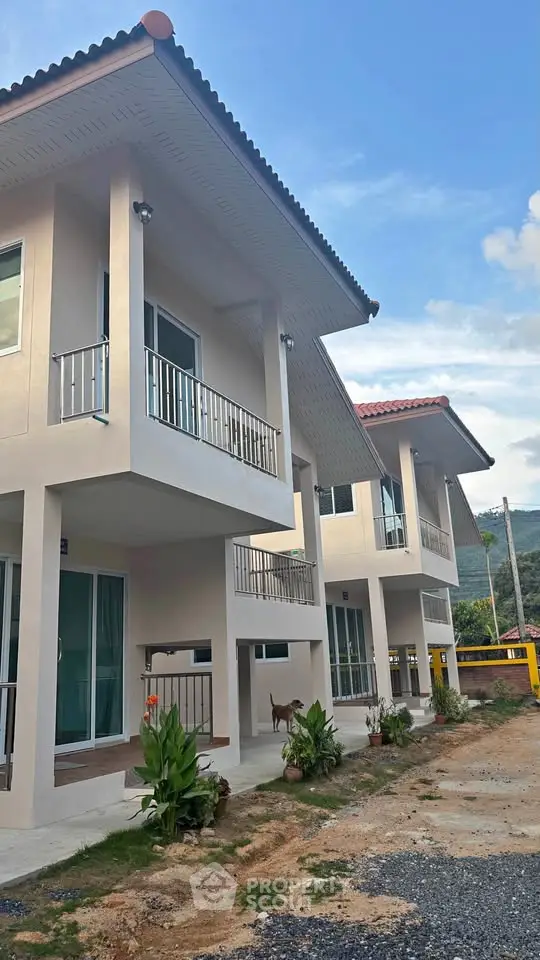Modern two-story residential buildings with balconies and lush surroundings.