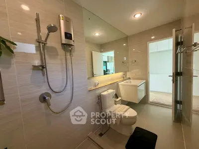 Modern bathroom with sleek fixtures and large mirror in a contemporary home.