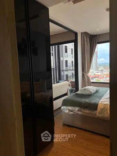 Modern bedroom with city view and balcony access in high-rise apartment